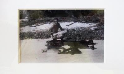 Fotografía en blanco y negro con hombre en la playa y pescado con marco de madera natural
