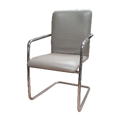 Sillón en metal cromado con tapicería de piel gris.